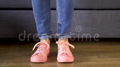 女人站在沙发边，穿着舒适的<strong>珊瑚色</strong>运动鞋露出双腿